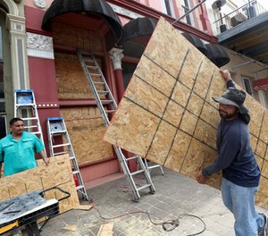 Workers set up sheets of plywood at a storefront in Galveston, Texas on Monday, Aug. 24. Hurricane Laura is expected to hit the Gulf Coast between Wednesday and Thursday and is projected to grow into a Category 3 hurricane.