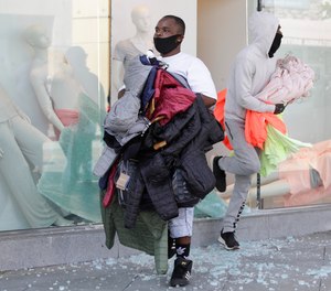 In this May 31, 2020, file photo, clothing is taken from The Gap store in Santa Monica, Calif., during unrest and protests over the death of George Floyd.