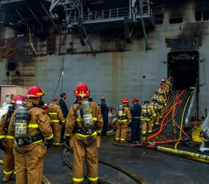 In this July 14, 2020 photo, sailors prepare to board the amphibious assault ship USS Bonhomme Richard to fight a fire in San Diego, Calif. A senior defense official says arson is suspected as the cause of the blaze, which burned for four days.