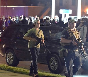 Kyle Rittenhouse, left, walks along Sheridan Road in Kenosha, Wis., Tuesday, Aug. 25, 2020, with another armed civilian.