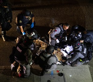 Police medics treat a man who was fatally shot during protests in Portland on Saturday.