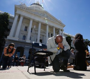 In this June 9, 2020, file photo, Assemblyman Mike Gipson, D-Carson, bows his head as he and other members of the California Legislature kneel for George Floyd at the Capitol in Sacramento, Calif. (AP Photo/Rich Pedroncelli, File)