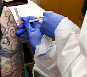 A nurse gives a volunteer an injection in a study for a possible COVID-19 vaccine developed by the National Institutes of Health and Moderna Inc. The IAFC has voiced its strong support for keeping first responders on the highest priority tier for a vaccine.