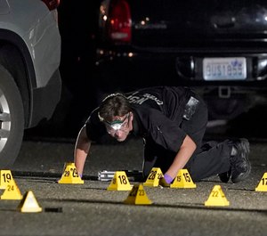 A Washington State Patrol Crime Lab worker looks at evidence markers in the early morning hours of Friday, Sept. 4, 2020, in Lacey, Wash. (AP Photo/Ted S. Warren)