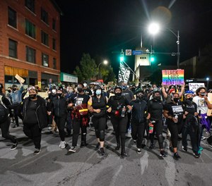 Demonstrators march along a street in Rochester, N.Y., Friday, Sept. 4, 2020, during a protest over the death of Daniel Prude.
