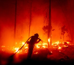 A firefighter battles the Creek Fire as it threatens homes in Madera County, Calif. Wildfires in California this year have set a new record, burning more than 2 million acres across the state.