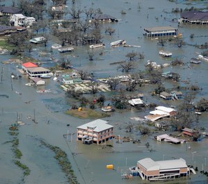In this Aug. 27, 2020 file photo, buildings and homes are flooded in the aftermath of Hurricane Laura near Lake Charles, La. (AP Photo/David J. Phillip, File)