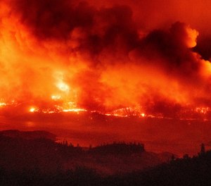 Firefighter Robert Daniels, a Hotshot working the BTU Complex, saved his own home from the Bear Fire using bottles and buckets of water. (AP Photo/Noah Berger)