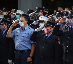 Firefighters salute in front of FDNY Ladder 10 Engine 10 near the 9/11 Memorial on Friday, Sept. 11, 2020, in New York. The federal government has agreed to pay back $3.3 million it took from the FDNY's 9/11 health program over the last four years.