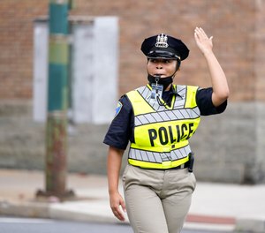 Cierra Thurmond, a cadet in the Baltimore Police Academy, directs traffic during an on the field class session in Baltimore.