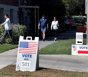 Voters head to a polling station to vote in Florida's primary election in Orlando, Fla.