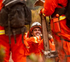 In this Aug. 17, 2020 photo, inmate firefighters rest during a break from battling the River Fire in Salinas, Calif. Gov. Gavin Newsom has signed a bill that would allow California's inmate firefighters to become professional firefighters after completing their sentences.