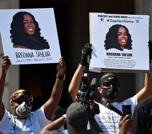 Signs are held up showing Breonna Taylor during a rally in her honor on the steps of the Kentucky State Capitol in Frankfort, Ky., Thursday, June 25, 2020. A Kentucky EMT who treated one of the officers involved in Taylor's fatal shooting has been placed on leave after posting about the case on Facebook.