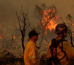 Members of the San Bernardino County Fire Department keep an eye on a flareup from the Bobcat Fire on Saturday, Sept. 19, 2020, in Valyermo, Calif. The Bobcat Fire doubled in size over the last week, becoming one of Los Angeles County's largest-ever wildfires. (AP Photo/Marcio Jose Sanchez)