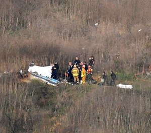 A body is covered, left, while another is seen at right at the scene of a helicopter crash that killed former NBA basketball player Kobe Bryant and eight others in Calabasas, Calif., Sunday, Jan. 26, 2020. (AP Photo/Mark J. Terrill, File)