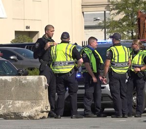 Police officers stand near barriers added to block access to downtown, Sept. 22, 2020 in Louisville.