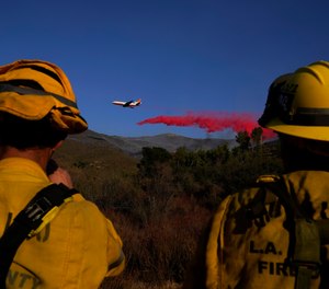 Fire crews from the Los Angeles County Fire Department watch an air tanker drop retardant onto the Martindale Fire, Monday, Sept. 28, 2020, in Santa Clarita, Calif.