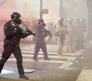 In this July 28, 2020, file photo, federal officers deploy tear gas and crowd control munitions at demonstrators during a Black Lives Matter protest at the Mark O. Hatfield United States Courthouse in Portland, Ore.