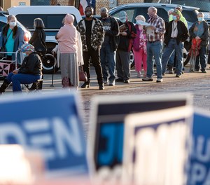 Voters line up outside the HUB to cast their ballots for early voting in the November presidential election Tuesday, Oct. 13, 2020, in downtown Tyler, Texas.