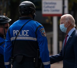 Former Vice President Joe Biden talks with Wilmington, Del., police officers as he departs The Queen theatre in Wilmington, Del., Monday, Oct. 19, 2020.