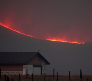 Flames rise from mountain ridges as a wildfire burns near Granby, Colorado, on Oct. 22, 2020.