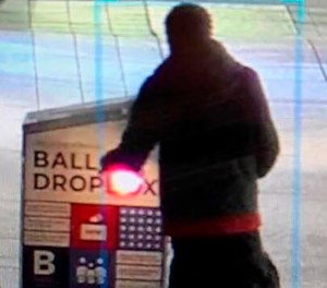 This surveillance image shows a man approaching a ballot drop box outside the Boston Public Library, early Sunday, Oct. 25, 2020, in downtown Boston.