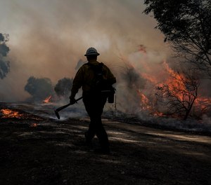 A firefighter prepares to put out hotspots while battling the Silverado Fire, Monday, Oct. 26, 2020, in Irvine, Calif. Orange County Fire Authority Chief Brian Fennessy said Tuesday that two firefighters who were critically injured in a burnover while battling the Silverado Fire are