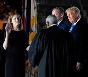President Donald Trump watches as Supreme Court Justice Clarence Thomas administers the Constitutional Oath to Amy Coney Barrett on the South Lawn of the White House in Washington, Oct. 26, 2020.