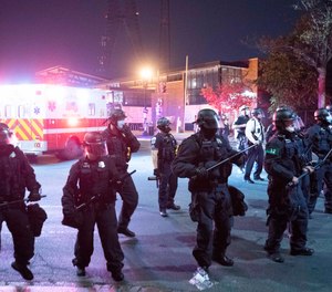 Washington Metropolitan Police Department police officers push back demonstrators outside of the fourth district police station in Washington, Wednesday, Oct. 28, 2020.