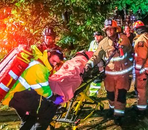 Atlanta firefighters transport a man they freed who was trapped in his third-floor bedroom after a tree came crashing down on a home as Tropical Storm Zeta swept across the Southeast Thursday, Oct. 29, 2020.