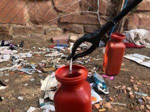 n this Aug. 9, 2019, file photo, a drug syringe found behind a vacant property in northeast Albuquerque, N.M., is placed into a container, as crews attempt to clear the lot of needles and other heroin paraphernalia.