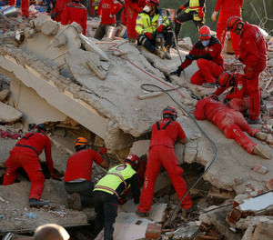 Members of rescue services search in the debris of a collapsed building for survivors in Izmir, Turkey, Sunday, Nov. 1, 2020. Rescue teams continue ploughing through concrete blocs and debris of collapsed buildings in Turkey's third largest city in search of survivors of a powerful earthquake that struck Turkey's Aegean coast and north of the Greek island of Samos, Friday Oct. 30, killing dozens and hundreds of others were injured.