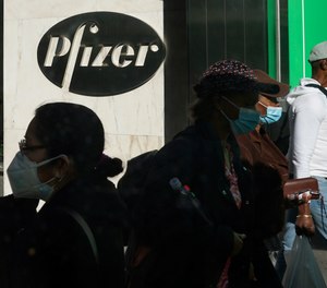 In this Nov. 9, 2020, file photo, pedestrians walk past Pfizer world headquarters in New York. Pfizer announced Wednesday, Nov. 18, 2020, more results in its ongoing coronavirus vaccine study that suggest the shots are 95% effective a month after the first dose.