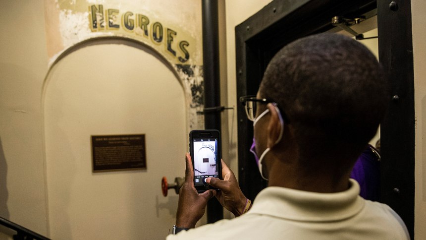 Dannion McLendon takes a photo of the historical marker placed and sign that reads "NEGROES" at the Ellis County Courthouse in Waxahachie, Texas, on Monday, Nov. 17, 2020.
