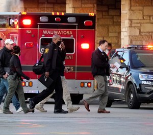 Police officials walk to the Mayfair Mall, Friday, Nov. 20, 2020, in Wauwatosa, Wis.