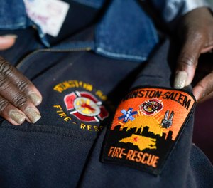Timika Ingram holds a jacket she had when she was a firefighter on Thursday, Nov. 19, 2020, in Charlotte, N.C. A group of Black firefighters in a North Carolina city have filed a grievance over conditions they have endured for more than 30 years.