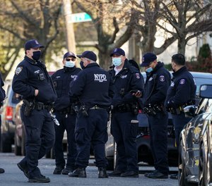 Police maintain a perimeter outside a crime scene, Tuesday, Nov. 24, 2020, in the Queens borough of New York.