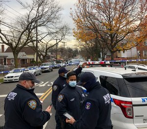 New York Police officers block off the street near the scene where a suspect was killed during a shootout with U.S. marshals in the Bronx that left two officers wounded, Friday, Dec. 4, 2020, in New York.