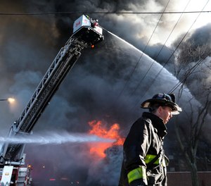 Firefighters work to extinguish a fire at a commercial building on Thursday, Dec. 10, 2020, in Chicago. Chicago Fire Department spokesman Larry Merritt says crews were called to flames shooting through the roof of Best Value Auto Body Supply Inc.