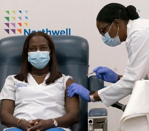 Sandra Lindsay, left, a nurse at Long Island Jewish Medical Center, is inoculated with the Pfizer-BioNTech COVID-19 vaccine by Dr. Michelle Chester, Monday, Dec. 14, 2020, in the Queens borough of New York. The first shipments of the vaccine are being sent out to healthcare facilities and nursing homes following the FDA's decision on Friday to approve its emergency use.