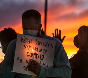 Family members of inmates incarcerated in the Utah Department of Corrections' prison system hold candles and say a prayer following a rally outside the Department of Corrections office.