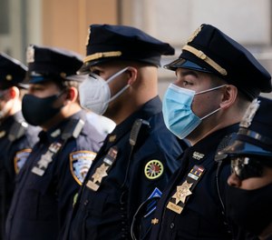 In this Oct. 5, 2020, file photo, NYPD officers stand during a service at St. Patrick's Cathedral in New York to honor colleagues who have died due to COVID-19 related illness.