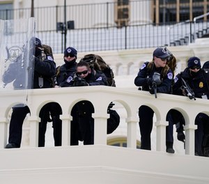 Police keep a watch on demonstrators who tried to break through a police barrier, Wednesday, Jan. 6, 2021, at the Capitol in Washington.