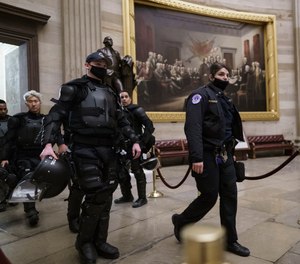 U.S. Capitol Police officers walk through the Rotunda as they and other federal police forces responded as violent protesters loyal to President Donald Trump stormed the U.S. Capitol in Washington, Wednesday, Jan. 6, 2021.