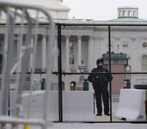 A member of the U.S. Capitol Police stands behind security fencing outside the Capitol Building in Washington, Friday, Jan. 8, 2021, in response to the January 6 storming of the U.S. Capitol.