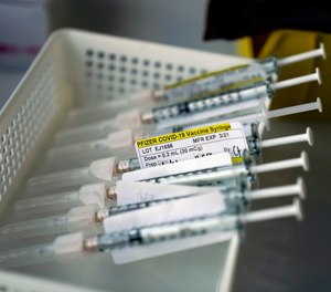 Syringes containing the Pfizer-BioNTech COVID-19 vaccine sit in a tray in a vaccination room at St. Joseph Hospital in Orange, Calif. President-elect Joe Biden announced Friday that he will end the current practice of holding back vaccine doses, a measure taken under the President Donald Trump administration to guarantee that people who get their first shot can also get their second shot.