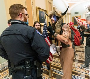 Jacob Anthony Chansley, who also goes by the name Jake Angeli, confronts U.S. Capitol Police officers inside the Capitol on Jan. 6.