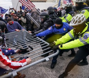 In this Jan. 6, 2021, file photo rioters try to break through a police barrier at the Capitol in Washington.
