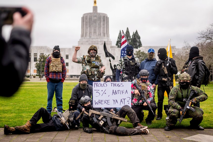 Armed protesters, who identified themselves as Liberty Boys, pose for fellow demonstrators' pictures outside the Oregon State Capitol on Sunday, Jan. 17, 2021, in Salem, Ore.