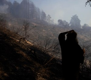 Watsonville, Calif., resident Kelly Klett looks in the direction of a burned area near her ranch on Tuesday, Jan. 19, 2021. Klett says 25 horses were evacuated from the ranch due to fires burning within 100 yards of her home. More than a dozen fires, likely ignited by strong winds, burned across Santa Cruz and San Mateo counties this week.